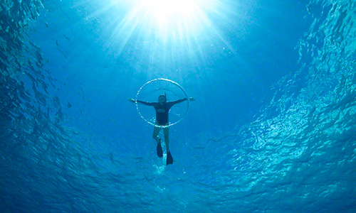 a diver seen through an air bubble from underneath