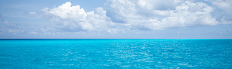 Turquoise ocean and cloudy skies.